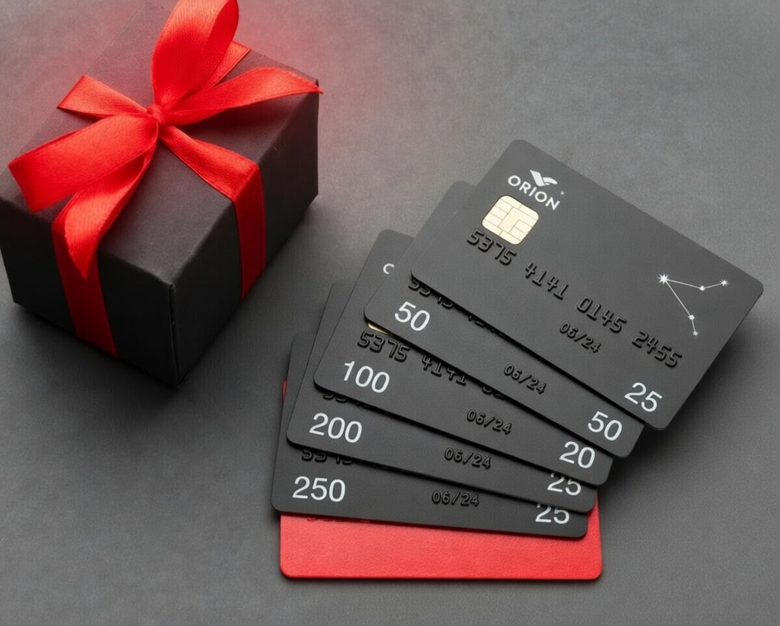 Set of black gift cards with red ribbon and box on a dark surface
